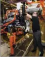  ?? THE ASSOCIATED PRESS ?? Yves Dontigny, plant launch manager at the General Motors Orion Assembly plant, points out a feature on the drive train before its installati­on into the Chevrolet Bolt EV on Friday in Orion Township, Mich.