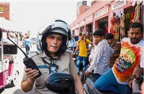  ??  ?? On the beat: Chodhuary on her radio at the old market in Jaipur. — AFP