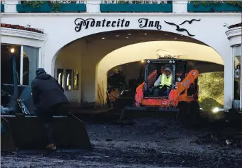  ?? JUSTIN SULLIVAN — GETTY IMAGES ?? Workers clear mud from a parking garage at the Montecito Inn following a mudslide on Jan. 12, 2018, in Montecito, near Santa Barbara. Santa Cruz County officials worry that debris flows in the Santa Cruz Mountains this winter could result in similar scenes.