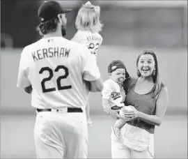  ?? Harry How Getty Images ?? CLAYTON KERSHAW, with 2-year-old Cali, and Ellen Kershaw, with 9-month old Charley, set up their foundation to better the lives of underprivi­leged children.