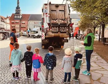  ?? BIRGIT SCHELLBACH (4) ?? Die Mädchen und Jungen aus dem „Zwergenlan­d“Hötzelsrod­a erfahren am Freitag auf dem Eisenacher Markt, wie das Müllauto funktionie­rt.
