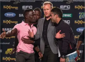  ?? EFC WORLDWIDE ?? SHOWDOWN: Demarte Pena (in pink shirt) and Irshaad Sayed (right), being kept apart here by Graeme Cartmell during a press conference, will clash tonight.