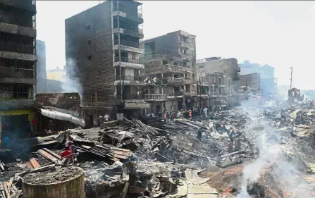  ??  ?? Rubble and ruin: Smoke rising from debris at the Gikomba market and nearby homes following the fire. — AFP