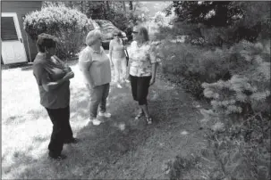  ?? The Associated Press ?? BACKYARD VISIT: Barbara Denegar, from left, Evelyn Guerra, Judy Bretzger and Sara Breslow talk Wednesday while visiting a neighbor’s backyard that is next to the Monmouth Mall in Eatontown, N.J. The four women are the plaintiffs in a court case against...