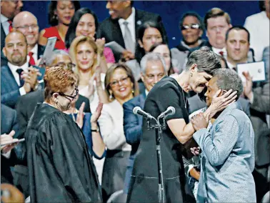  ?? JOSE M. OSORIO/CHICAGO TRIBUNE PHOTOS ?? Lori Lightfoot, right, is hugged by wife Amy Eshleman after Lightfoot was sworn in as mayor at Wintrust Arena in Chicago on Monday.