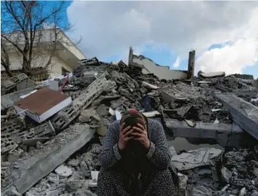  ?? KHALIL HAMRA/AP ?? A distraught woman sits on rubble Tuesday in Nurdagi, a Turkish town near the earthquake’s epicenter.