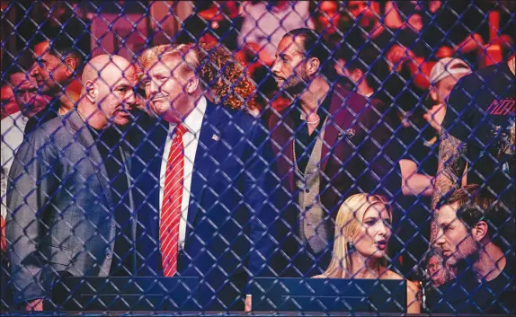  ?? PHOTOS BY SCOTT MCINTYRE / THE NEW YORK TIMES ?? Dana White, the CEO of Ultimate Fighting Championsh­ip, speaks with former President Donald Trump ringside at UFC 299, a mixed martial arts event March 9 in Miami. Perched at the intersecti­on of sports, business and the forever culture wars, White has steered his once-teetering cage-fighting enterprise to the carnivorou­s heart of the national mainstream. Seated at right are Ivanka Trump and Jared Kushner.