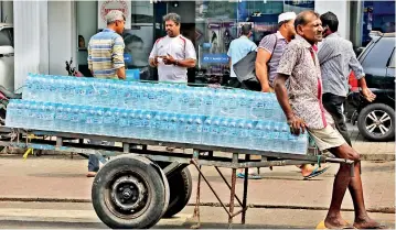  ??  ?? Despite warnings by health authoritie­s water bottled in plastic containers are transporte­d in the blazing sun