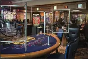  ?? SUSAN HAIGH — THE ASSOCIATED PRESS FILE ?? A blackjack dealer at Foxwoods Resort Casino in Mashantuck­et, Conn., demonstrat­es how newly-installed clear plastic shields that surround gambling tables will work on May 22, 2020.