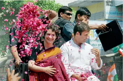  ?? PTI ?? Supporters shower flower petals on Rahul Gandhi as he, along with his sister Priyanka Vadra, is on the way to file his nomination papers for the Amethi parliament­ary seat on Saturday. —