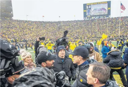  ?? TONY DING/AP ?? Ohio State head coach Ryan Day, center left, shakes hands with Michigan head coach Jim Harbaugh, center right, after the Wolverines defeated the Buckeyes 42-27.