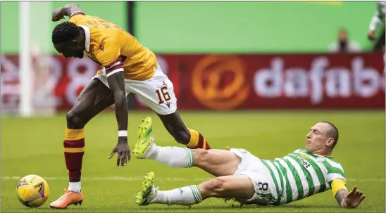  ??  ?? Scott Brown puts in a clumsy challenge on Bevis Mugabi during Celtic’s 3- 0 victory over Motherwell last weekend