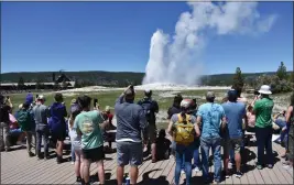  ?? MATTHEW BROWN — THE ASSOCIATED PRESS ?? The Old Faithful geyser erupts and shoots water and steam into the air as tourists watch and take photos in Yellowston­e National Park in Wyoming on Wednesday.