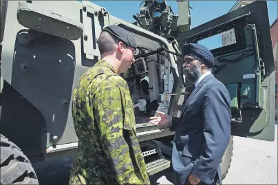  ?? CP PHOTO ?? Minister of National Defence Minister Harjit Sajjan speaks with Cpl. Kevin Huard following the announceme­nt of the Canadian Defence Review in Ottawa on Wednesday.