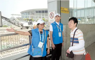  ??  ?? Wang Li (left) and Wan Yifeng point the way for passengers coming out of East Xujing Metro station. The “Smiling Clovers” — volunteers in Xujing Town in Qingpu District — are all geared up for the first China Internatio­nal Import Expo. — Jiang Xiaowei