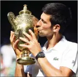  ?? The Associated Press ?? Novak Djokovic of Serbia kisses the trophy after defeating Kevin Anderson of South Africa in the men's singles final match at the Wimbledon Tennis Championsh­ips in London, Sunday.