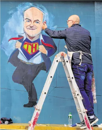  ?? PHOTO: GARETH CHANEY/COLLINS ?? Hero’s welcome: Artist Niall O’Loughlin paints a mural of chief medical officer Tony Holohan at Devitt’s Pub on Camden Street, Dublin