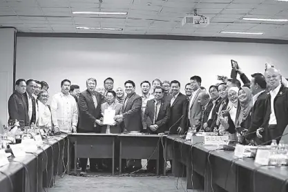  ?? MIGUEL DE GUZMAN ?? Members of the bicameral conference committee and the Bangsamoro Transition Commission together with MILF leaders pose with the Organic Law for the Bangsamoro Autonomous Region at the Senate last night.