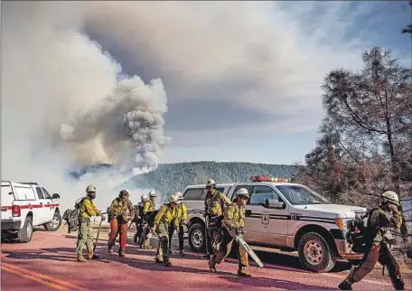  ?? Noah Berger Associated Press ?? A HAND CREW heads out along Mosquito Ridge Road to battle the Mosquito fire near Foresthill in Placer County — at 30,000 acres, among the largest of the year in the state. At least 8,000 people were under evacuation orders; many had concerns about their animals.