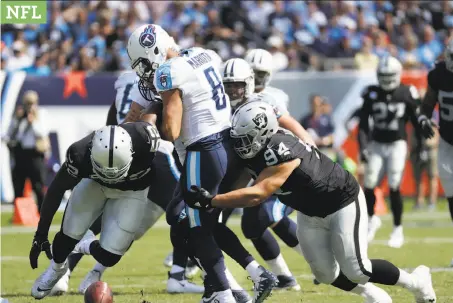  ?? James Kenney / Associated Press ?? Raiders defensive linemen Eddie Vanderdoes (right) and Khalil Mack chase a fumble by Tennessee QB Marcus Mariota.