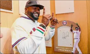  ?? Hans Pennink / Associated Press ?? Hall of Fame inductee David Ortiz reacts after signing the board where his plaque will hang while visiting the Baseball Hall of Fame and Museum on Monday.