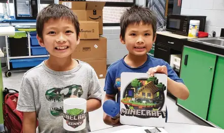  ?? CONTRIBUTE­D ?? Children show off a Minecraft mug and sign created with Creativity Commons equipment inside Washington Township RecPlex on Thursday. The makerspace initiative is powered by Washington Twp.-Centervill­e Public Library and takes place in 800 square feet of leased space within the RecPlex.