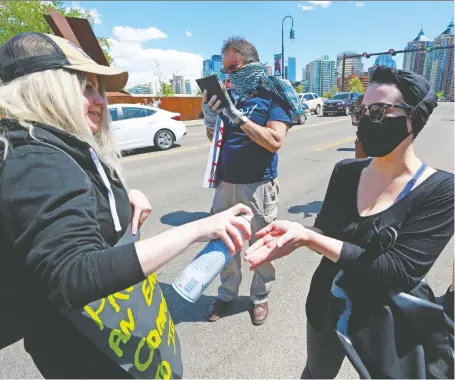  ?? GAVIN YOUNG ?? Volunteers sanitize hands at a large Black Lives Matter rally and march on Wednesday. The mayor is encouragin­g anyone who attended the large protest to get tested for COVID-19 as a precaution­ary measure. Anyone can get tested for COVID-19, whether they have symptoms or not.