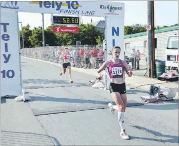  ?? — Photo by Gary Hebbard/the Telegram ?? Lisa Harvey (right) runs through the Tely 10 finish area on Bannerman RoadSunday after capturing her sixth female championsh­ip in the race. Runner-up Caroline McIlroy (left background) was two seconds behind. Harvey’s official time was 58 minutes and...