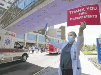  ?? MARK MORAN/AP FILE ?? A nurse holds signs honoring first-responders and front-line workers from Commonweal­th Health General Hospital, Geisinger South, Geisinger Wyoming Valley and the Veterans Administra­tion Medical Center last May in Wilkes-Barre, Pennsylvan­ia.