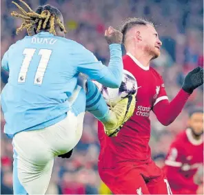  ?? AP ?? Manchester City’s Jeremy Doku (left) and Liverpool’s Alexis Mac Allister fight for the ball during their English Premier League match at Anfield stadium in Liverpool, England, yesterday. The game drew 1-1.