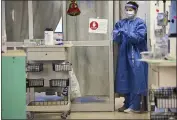  ?? JULIE BENNETT — THE ASSOCIATED PRESS ?? A nurse puts on rubber gloves before entering a COVID-19 patient’s room in East Alabama Medical Center’s intensive care unit in Opelika, Ala., on Dec. 10.