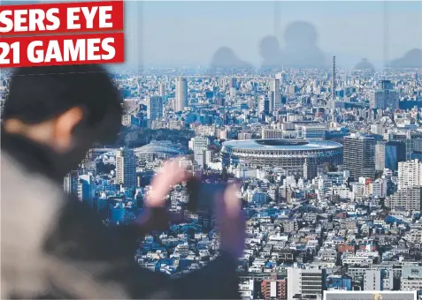  ?? Pictures: AFP, AP ?? FORGING AHEAD: A tourist takes a photo of the Japan National Stadium where Tokyo Olympics officials are keen to stage the Games in July 2021. Inset: The Olympic flame.