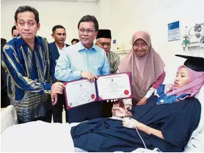  ??  ?? Morale-boosting: Shafie Apdal, who is also UMS pro-chancellor, presenting Fatma her graduation scroll.