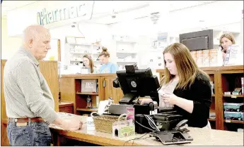  ?? LYNN KUTTER ENTERPRISE-LEADER ?? Larry Bell, who opened Bell Pharmacy about 50 years ago, makes a purchase from the store. His granddaugh­ter, Madison Patrick, checks him out. Bell said he understood the decision to close the pharmacy. He worked 37 years as a pharmacist.