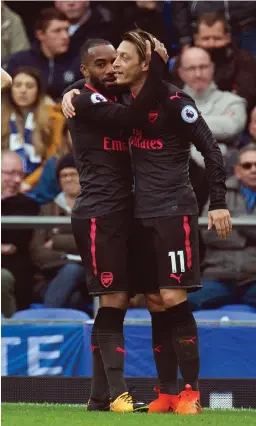 ??  ?? EASY PICKINGS: Arsenal’s Alexandre Lacazette celebrates scoring Arsenal’s third goal with Mesut Ozil, who also found the net against Everton.