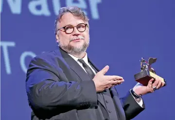  ??  ?? Del Toro holds the Golden Lion award for the best movie ‘The Shape of Water’ during the awards ceremony at the Venice festival, on Saturday. — Reuters photo