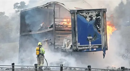  ?? Picture: Gareth Jennings. ?? A firefighte­r tackles the lorry blaze which broke out on the A90 on Saturday.