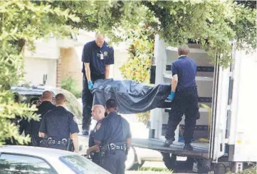  ??  ?? The third of eight bodies being loaded into the coroner’s truck at the scene of a shooting. — Reuters photo