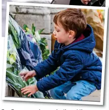  ??  ?? Top: Two women hug each other at the gates. Below: A boy lays a bunch of flowers