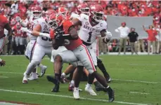  ?? JOHN BAZEMORE/AP ?? Georgia running back Zamir White gets past Arkansas defensive back Jalen Catalon to score a touchdown Saturday in Athens, Ga.