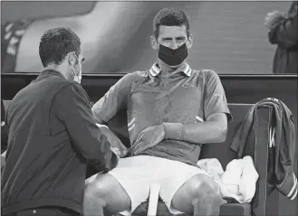  ?? ANDY BROWNBILL/AP PHOTO ?? Novak Djokovic receives treatment during his third round match against Taylor Fritz on Friday at the Australian Open in Melbourne, Australia. Djokovic won 7-6 (1), 6-4, 3-6, 4-6, 6-2.