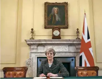  ?? Christophe­r Furlong/AFP ?? A primeira-ministra britânica Theresa May diante da carta que dará início ao ‘brexit’
