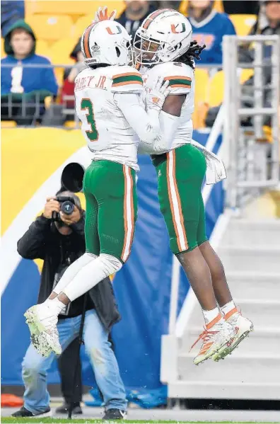  ?? JOE SARGENT/GETTY ?? Miami’s K.J. Osborn, right, celebrates his fourth-quarter touchdown Saturday against Pittsburgh with teammate Mike Harley.