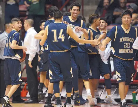  ?? ADOLPHE PIERRE-LOUIS/JOURNAL ?? Atrisco Heritage Academy team members celebrate their 55-47 quarterfin­als victory over Oñate, Class 6A’s top-seeded boys team, on Wednesday at the Pit. The Jaguars advance to today’s semifinal round against a familiar opponent, Volcano Vista.