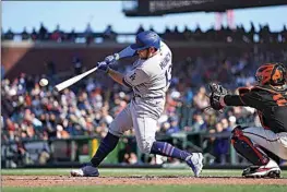  ?? TONY AVELAR / AP ?? The Dodgers’ Max Muncy hits a single against the Giants during the fourth inning Saturday in San Francisco. The Dodgers won 6-3