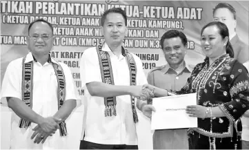  ??  ?? Peter (second left) presenting the appointmen­t letter as a native chief for Apin-Apin Bingkor area, Enggrieth Ebik.