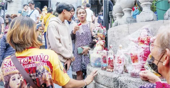  ?? PHOTOGRAPH BY YUMMIE DINGDING FOR THE DAILY TRIBUNE @tribunephl_yumi ?? IMAGES of the Holy Child are being sold at Tondo Church in Tondo, Manila on Sunday as celebratio­ns for the Feast of Sto. Niño in the country commences.