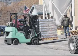  ??  ?? Cases of beer are taken out of the Commons Roots Brewing Co. on Saratoga Avenue. Employees were able to salvage some of the beer. Other breweries are working on plans to help out.