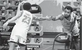  ?? MARK HUMPHREY/AP ?? Maryland’s Aquan Smart (23) slaps hands with Eric Ayala in the final seconds of Monday night’s game against Alabama in Indianapol­is.