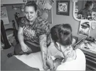  ?? CP PHOTO ?? Tattoo artist Lizzie Renaud, right , owner of Speakeasy Tattoo, outlines a stencil design on Sabrina Johnston before covering up her Hedley-inspired tattoo, in Toronto on Monday, March 12, 2018.